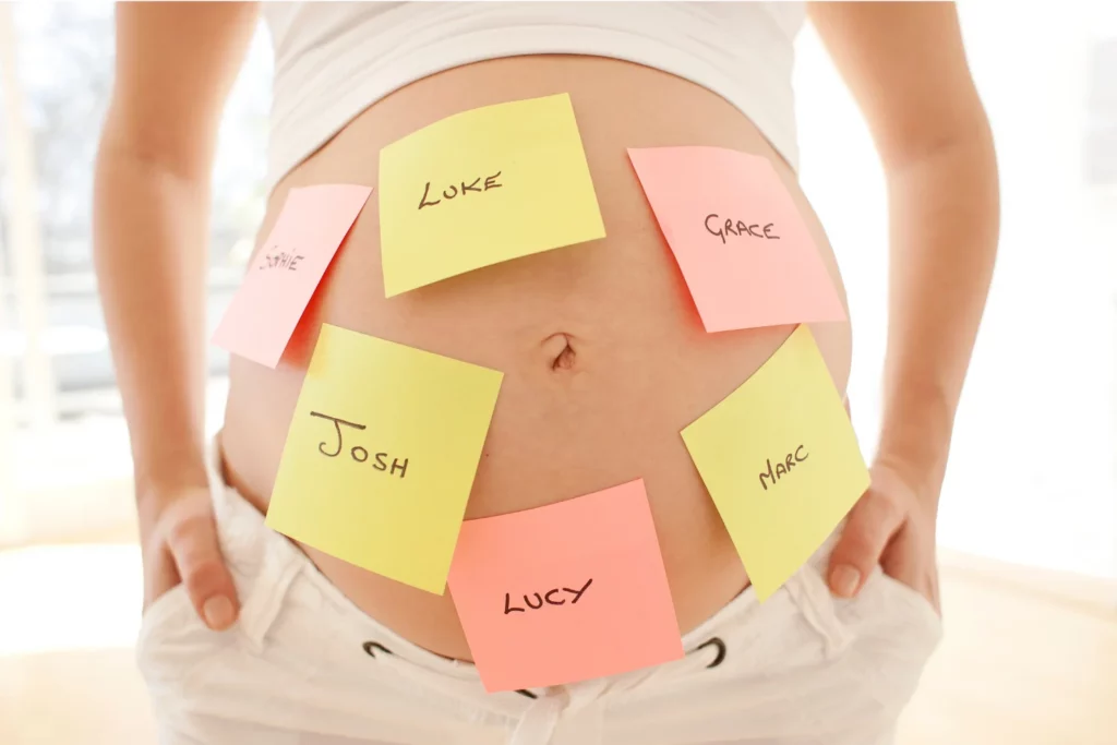 Bauch mit bunten Klebezetteln „Luke“, „Grace“, „Sophie“, „Josh“, „Marc“, „Lucy“