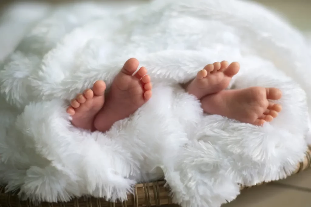 Babyfüße unter weißer Decke